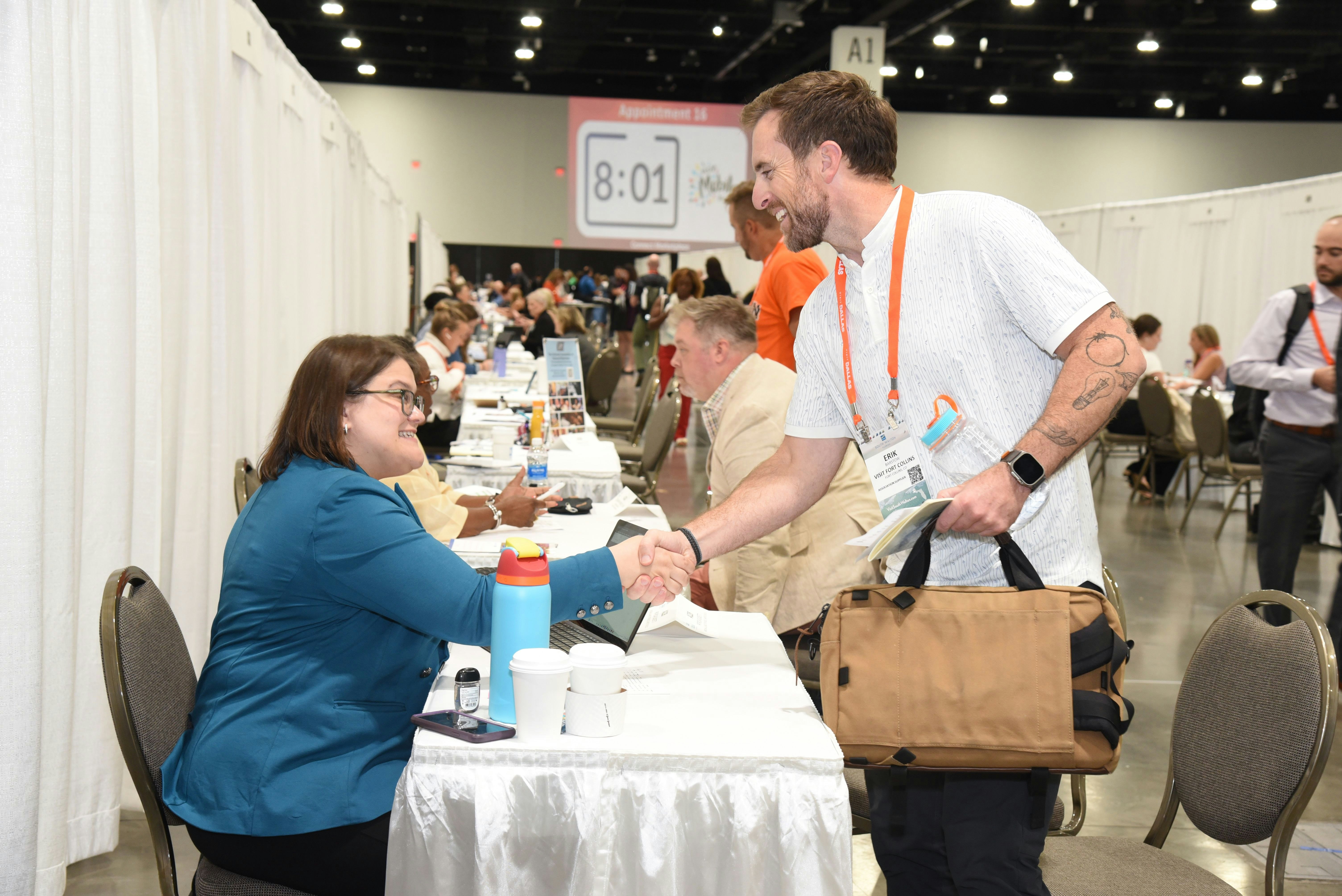 Two people shaking hands and introducing themselves during marketplace appoitments.