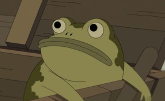 A very round green frog with a wide mouth hangs over the edge of a box he was inside.