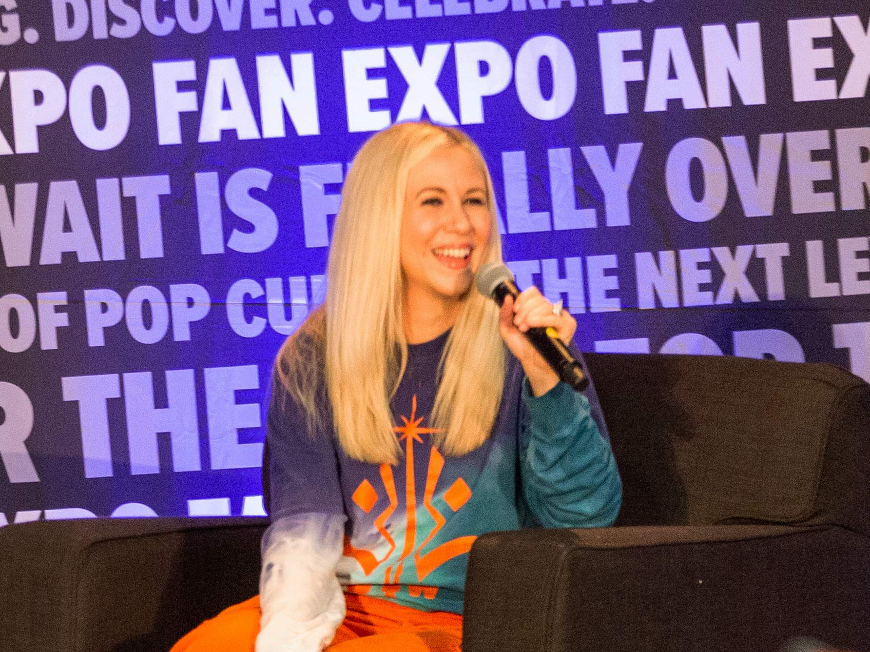 Ashley Eckstein on stage holding a microphone