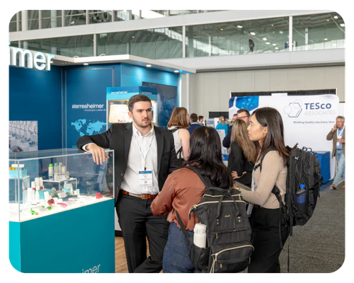 Several individuals clustered around a display case at an event, interacting with the exhibits on display