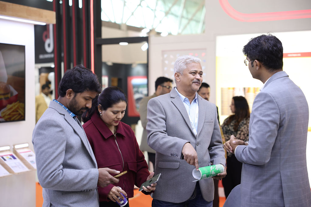 Attendees walking through the corridor, exploring various booths on display at Paperex