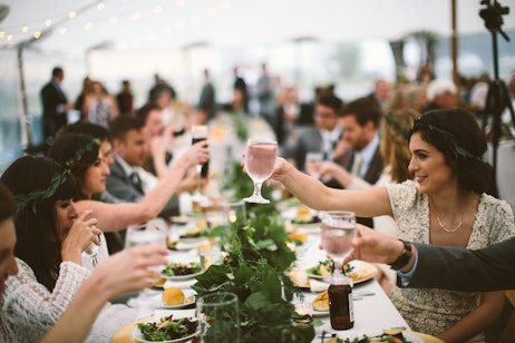 table of guests raising their glasses