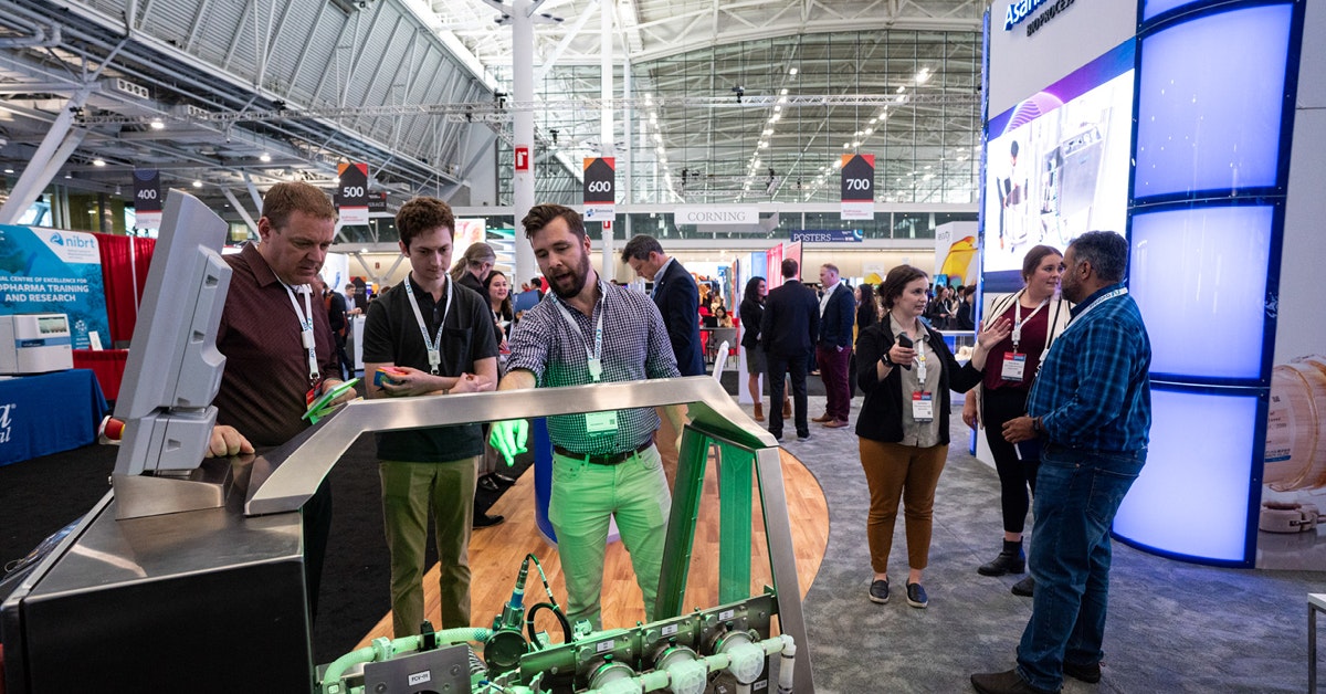 Attendees speak to exhibitors and BioProcess International