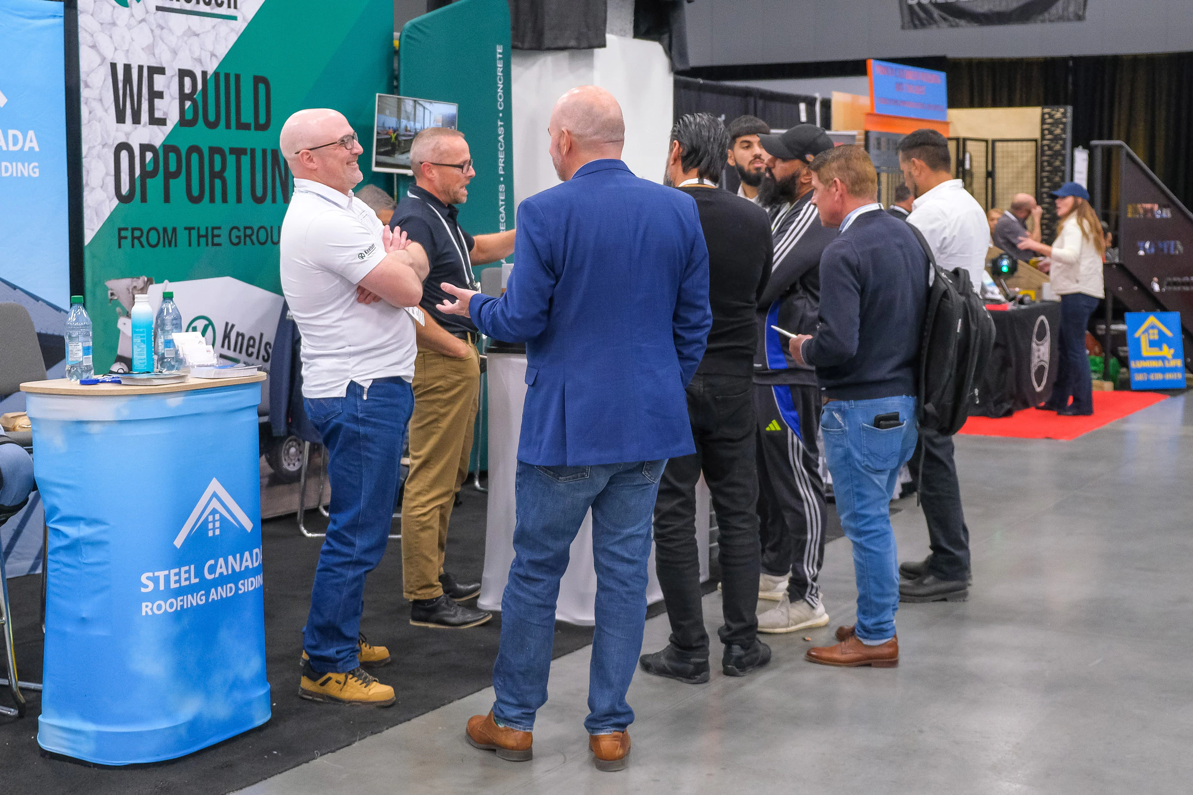 Attendees chatting with an exhibitor from Steel Canada on the BUILDEX Alberta expo floor