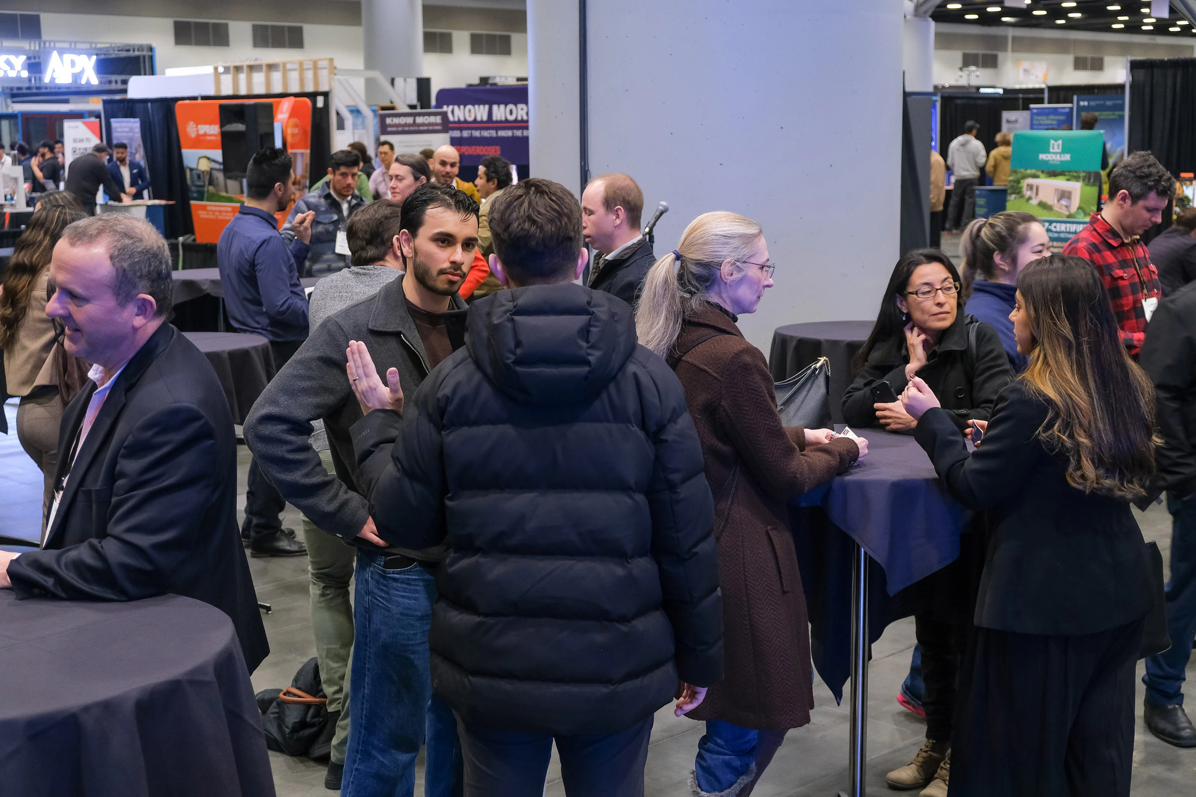 BUILDEX attendees networking during a mixer session on the expo floor