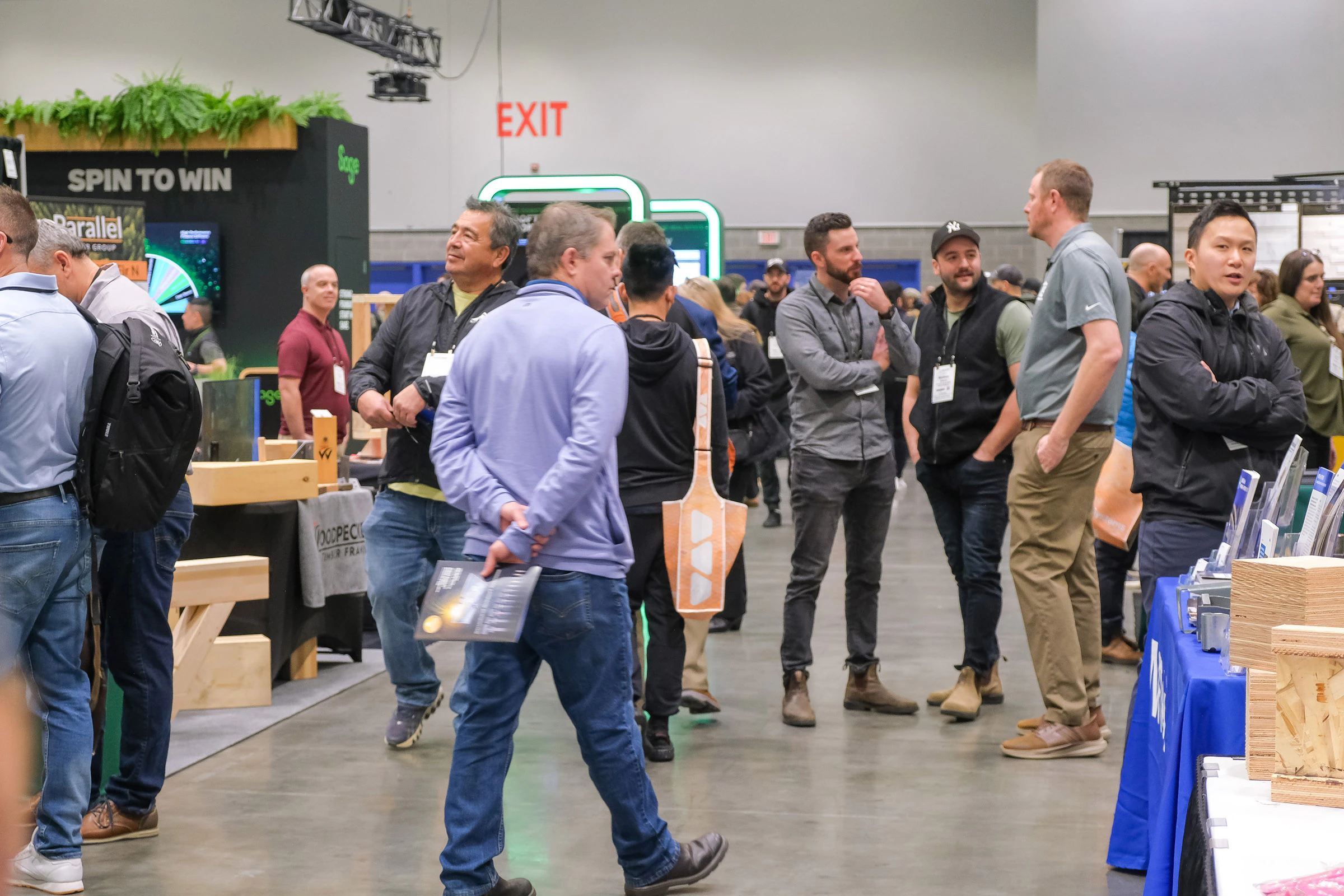 A look down a busy aisle on the BUILDEX Vancouver expo floor with conversations happening