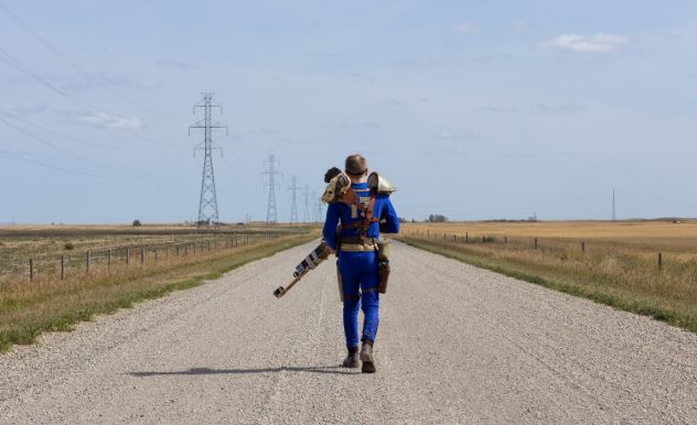 Medicore Mimicry walking down an empty road with his back to us