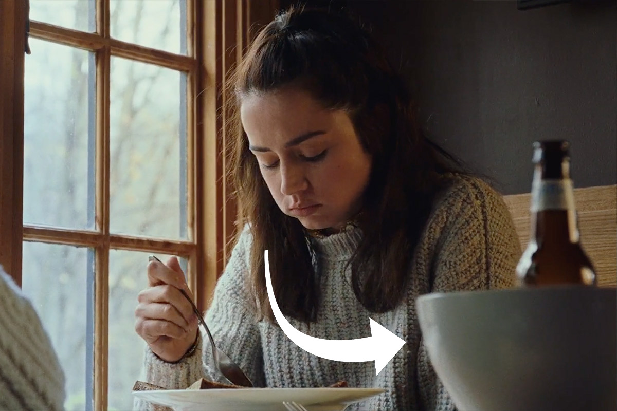 Marta eats at a restaurant with a beer and empty bowl in front of her