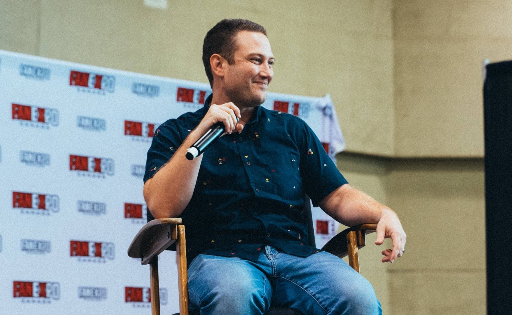 Bryce Papenbrook smiles as he listens to a fan asking a question off camera