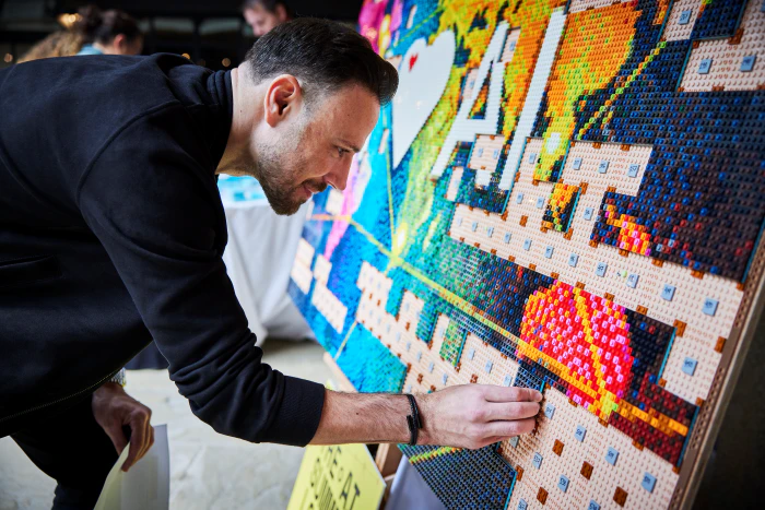Attendee adds to the LEGO wall at The AI Summit London