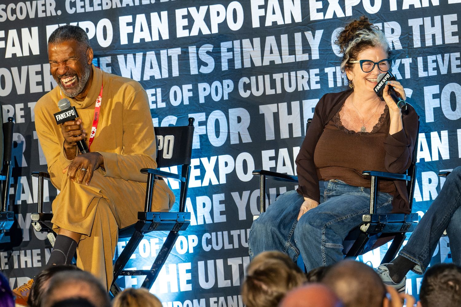 Four members of the Aliens cast share the stage, laughing together during their panel.