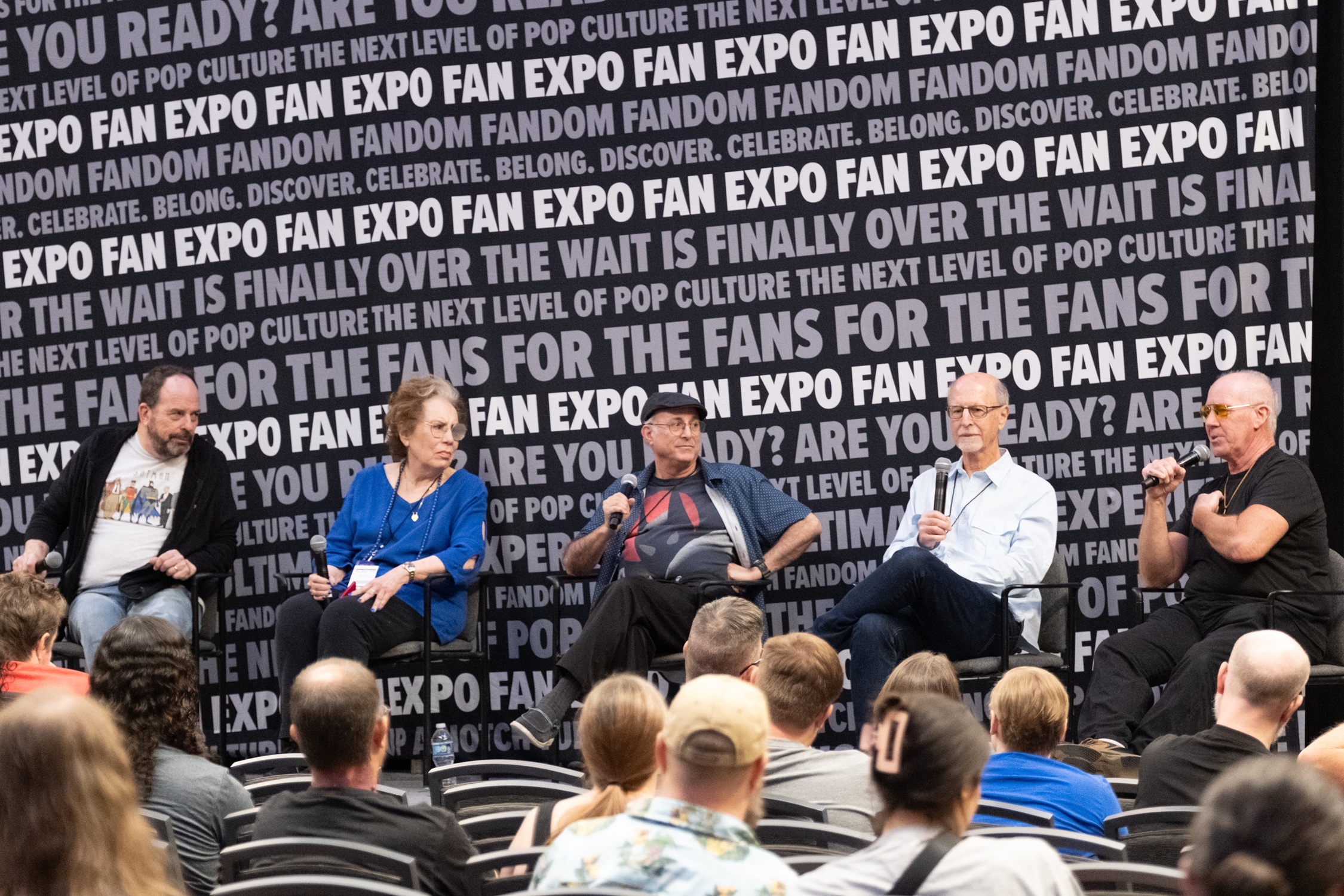 Loren Lester, Diane Pershing, Dan Riba, Stan Berkowitz, and Kevin Altieri sit on stage during a Batman: The Animated Series panel, discussing their experiences creating the beloved show.