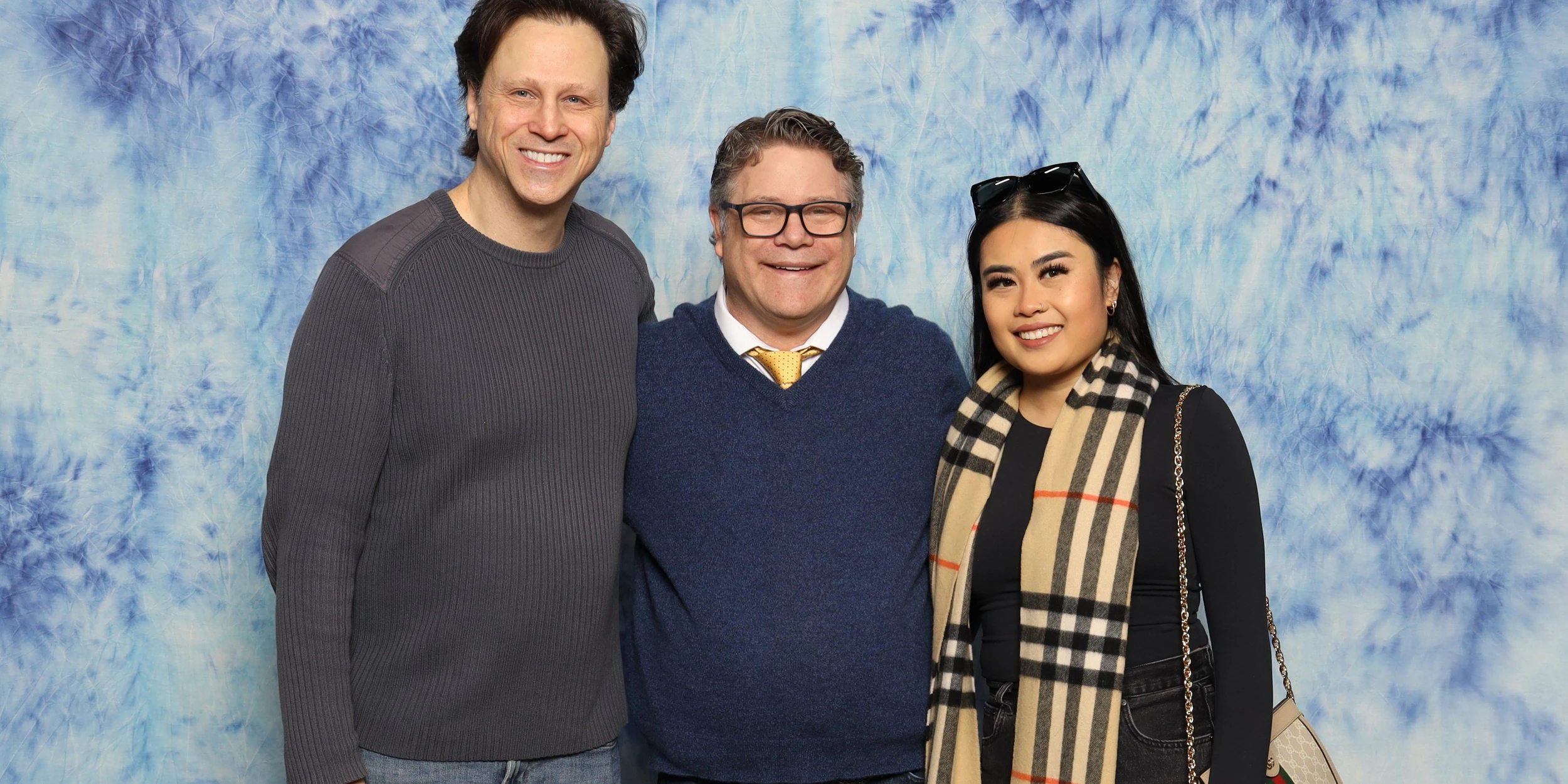 Sean Astin posing for a professional photo with fans during a FAN EXPO Dallas photo op.