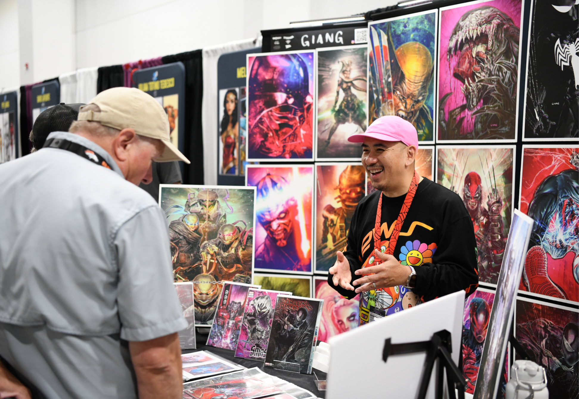 comic creator guests posing for photo with fan at autograph booth