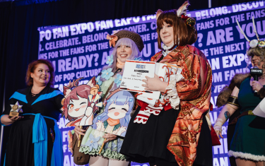 Two women cosplaying as Ichi-Heme & Hinata Takanashi-Mahjong Soul with their "Best Journeyman" award at the Cosplay Craftsmanship Cup.