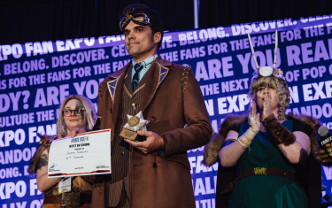 A man cosplaying as the 10th Doctor from Dr. Who with his "Best in Show" award at the Cosplay Craftsmanship Cup.
