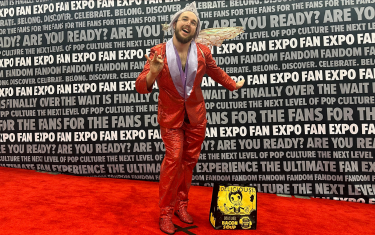 A man cosplaying as the Fairy Godmother from Shrek 2 posing on the Cosplay Red Carpet.
