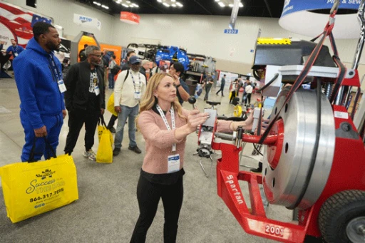 Industry professionals looking at equipment on the WWETT show floor