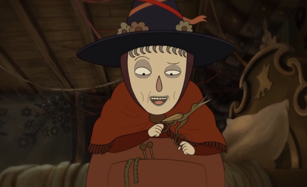 An older woman clad in all red with a brick red shall around her shoulders and a black hat covered in flowers, picks up scissors in the shape of a bird. 