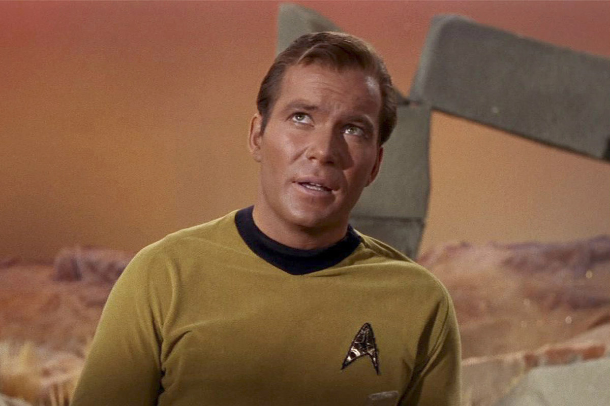 Captain Kirk stands on a planet and looks up