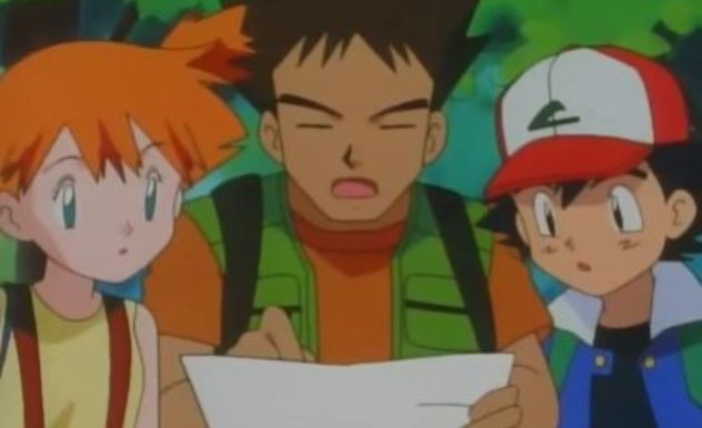 misty brock and ash look at a map in a forest