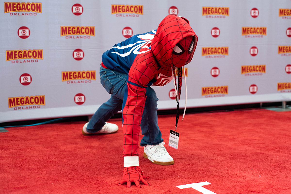 A young Spider-Man poses on the floor at the Red Carpet