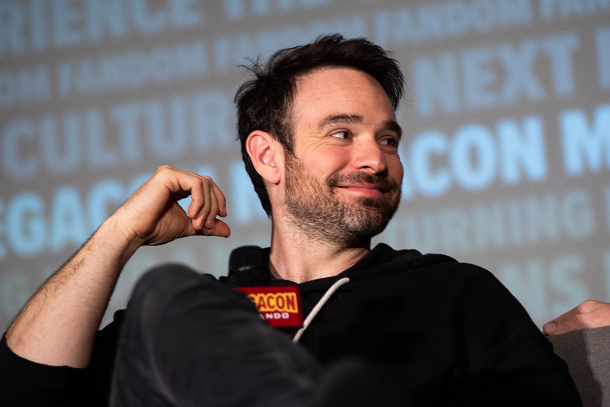 Charlie Cox smiles while looking to his left