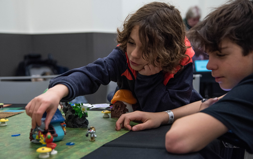 two young boys playing a Smurfs tabletop game