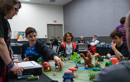 a group of young boys playing a table top game