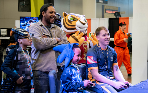 a group of adults and young boys playing video games