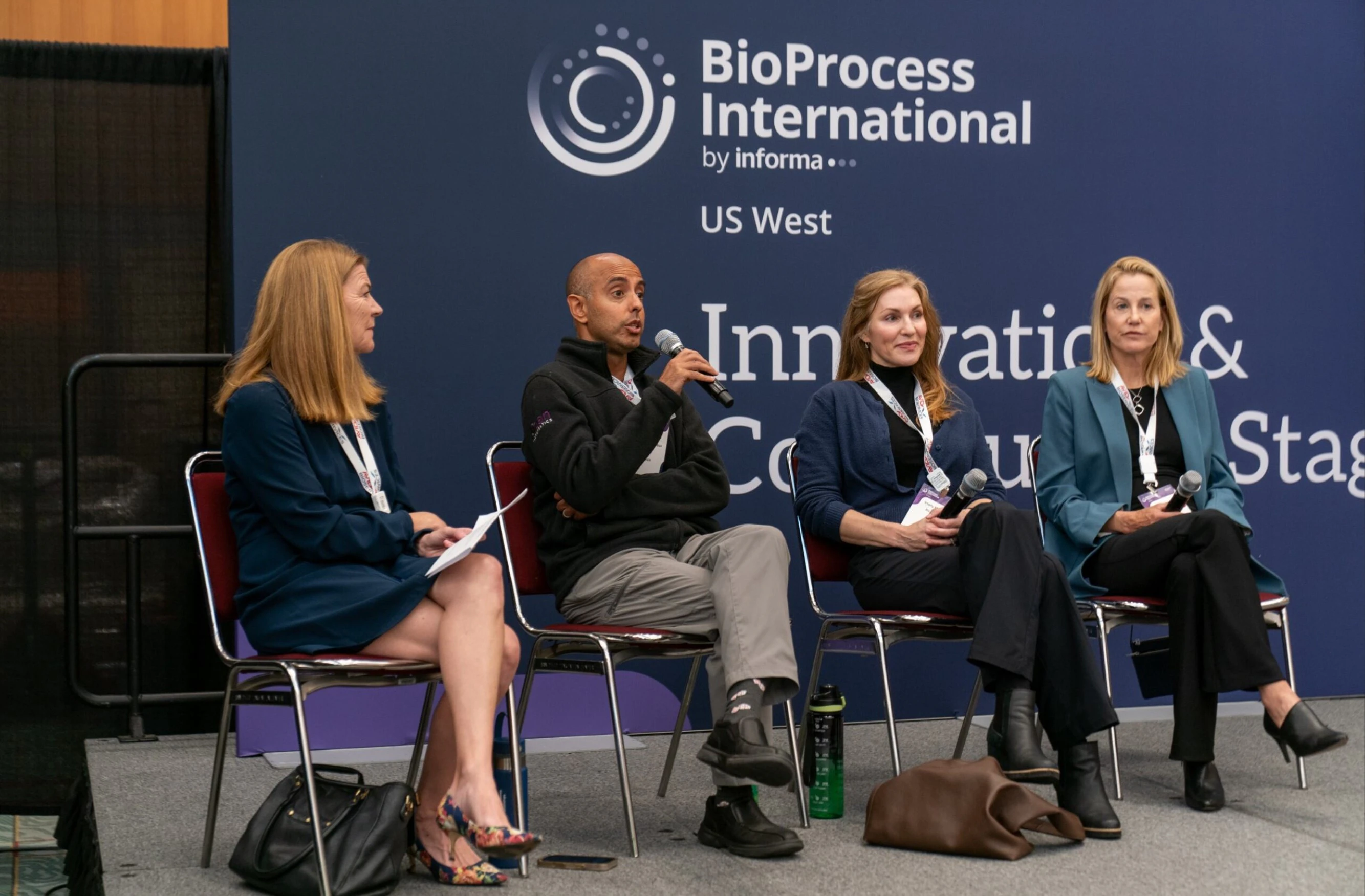 Panellist sit on stage in discussion in front of an audience at BioProcess International US West