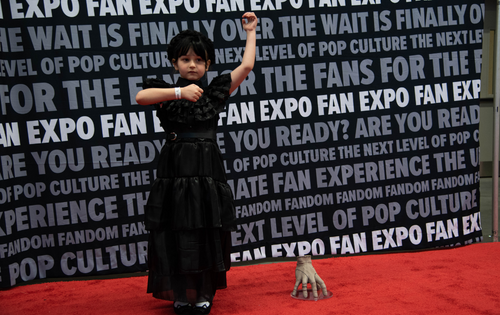 a young girl cosplaying as Wednesday Addams from the show Wednesday