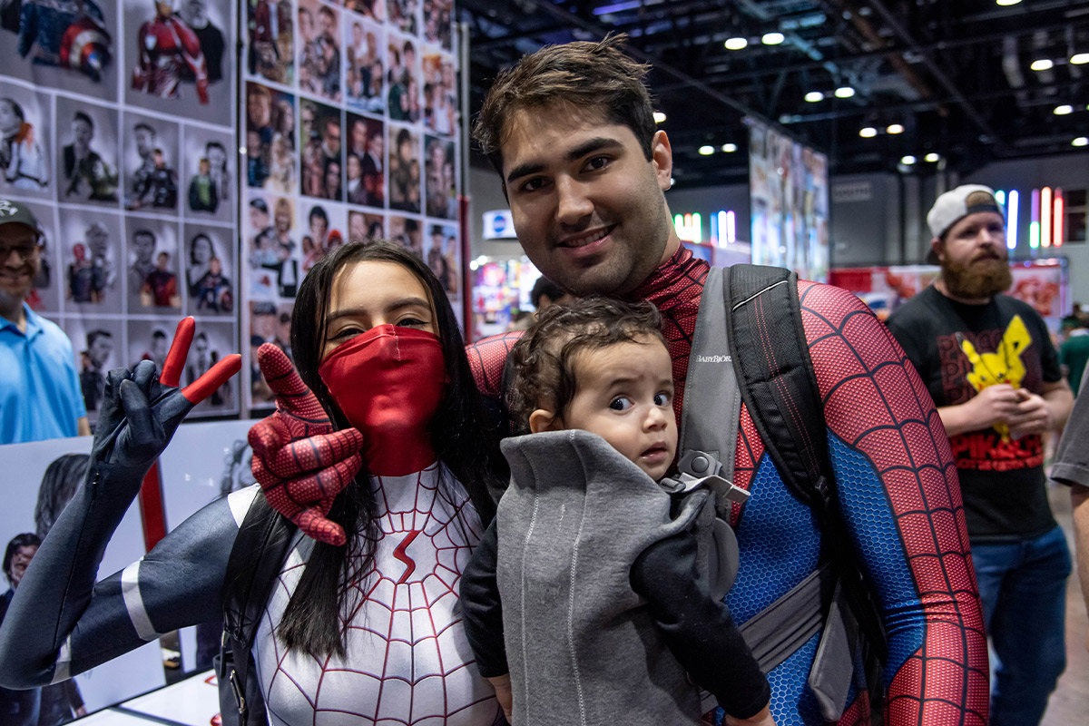 A family of Spider-Man cosplayers smile at the camera