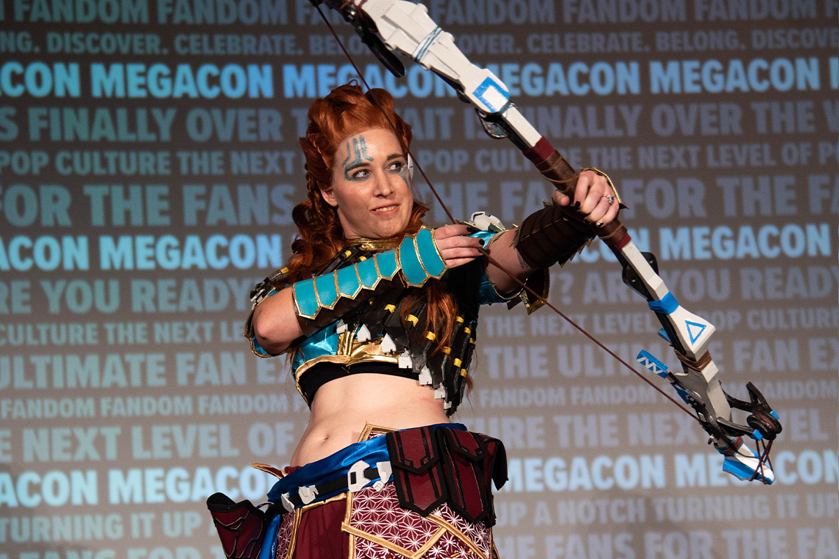 A cosplayer weilding a bow & arrow