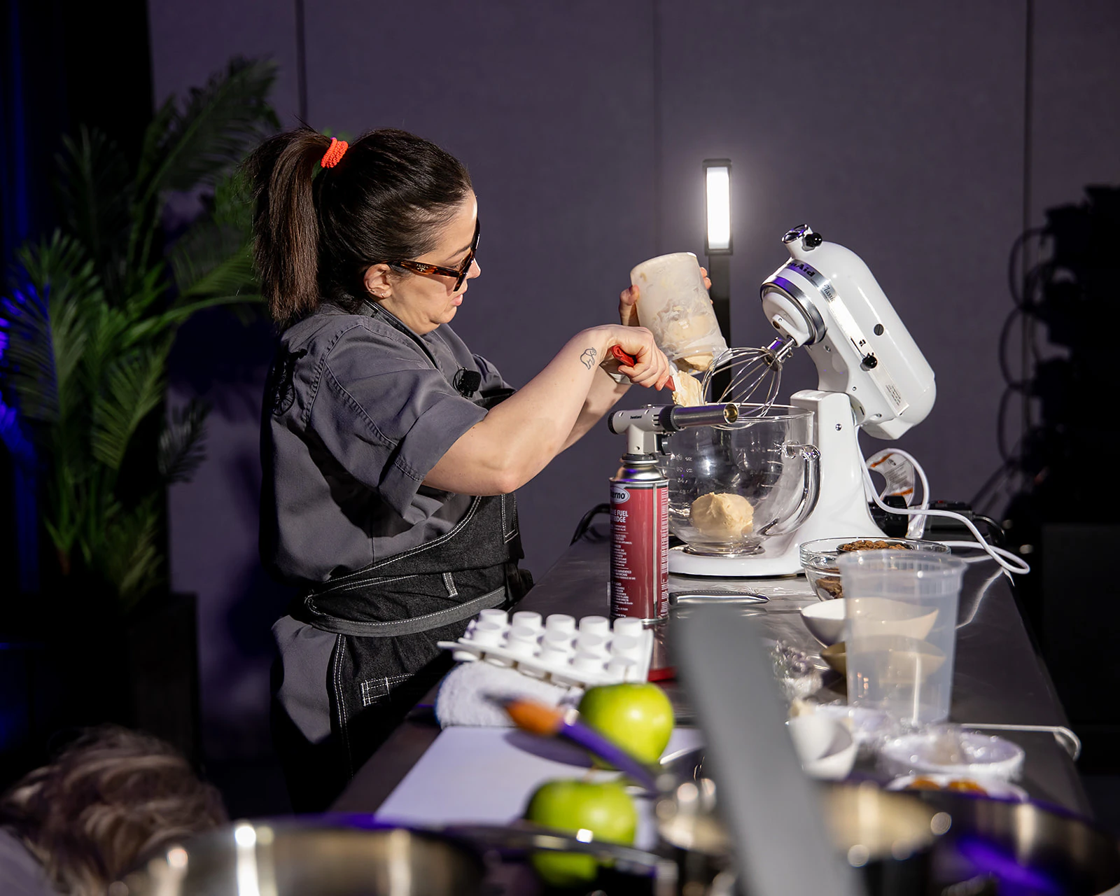 Female chef cooking on stage at Cater+Event