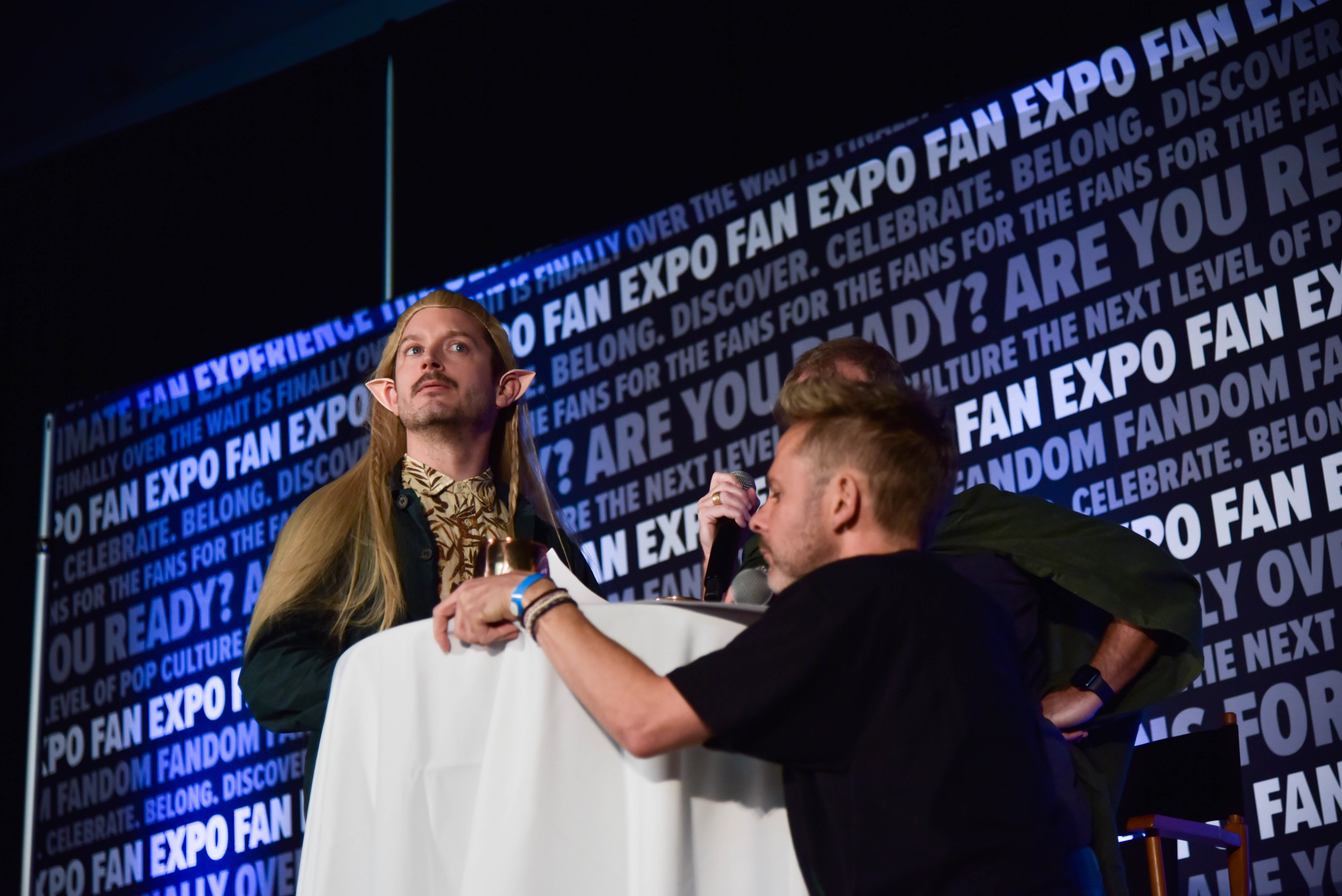 Elijah Wood (acting as Legolas) with Dominic Monaghan (acting as Gollum) across him at their special event.