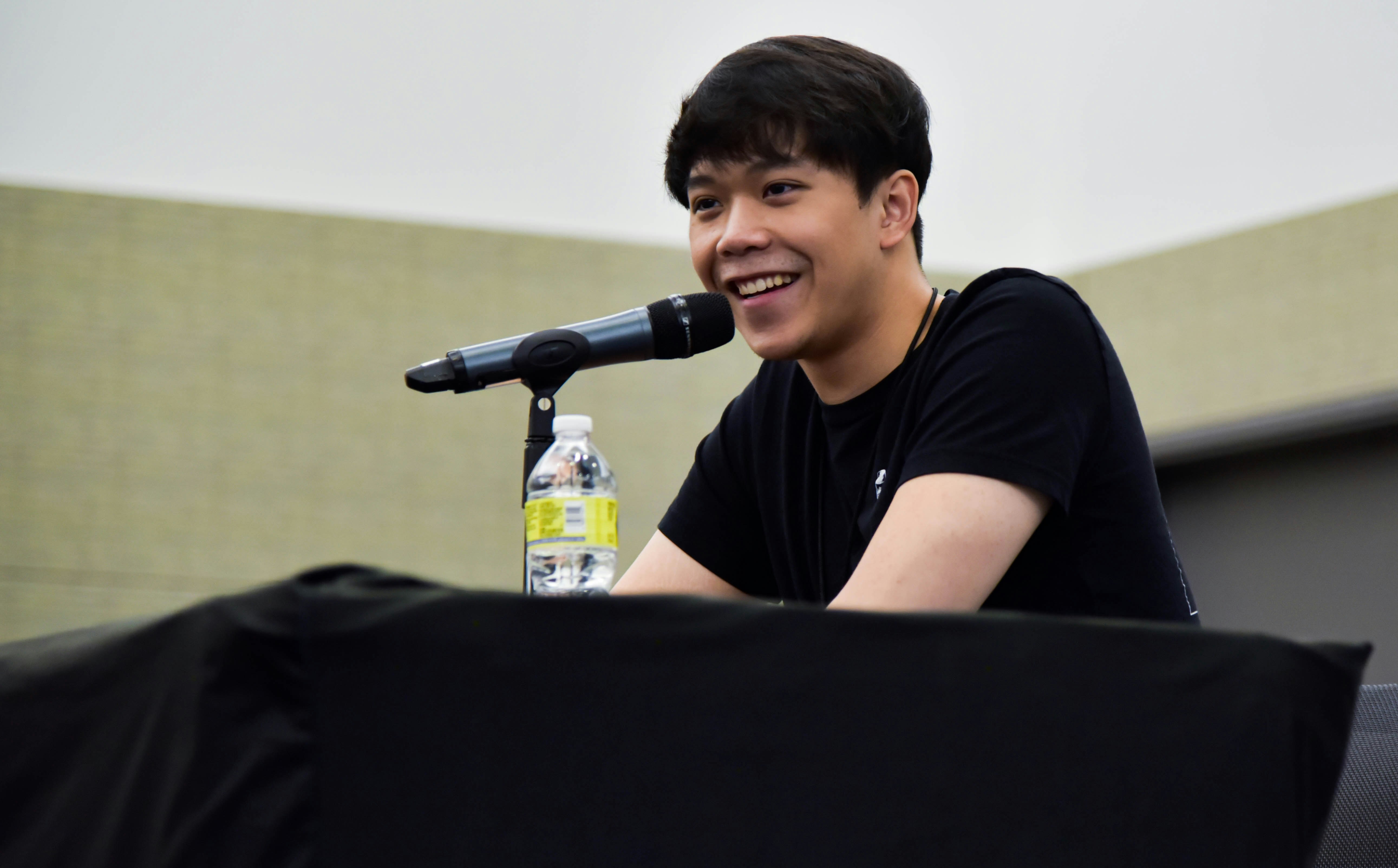 Aleks Le smiling at his solo panel, after hearing a fan's question.