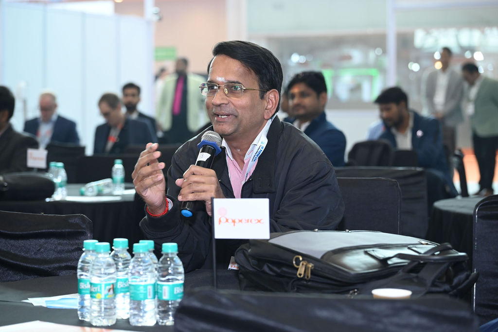Attendees and speakers chatting before the start of a conference session.