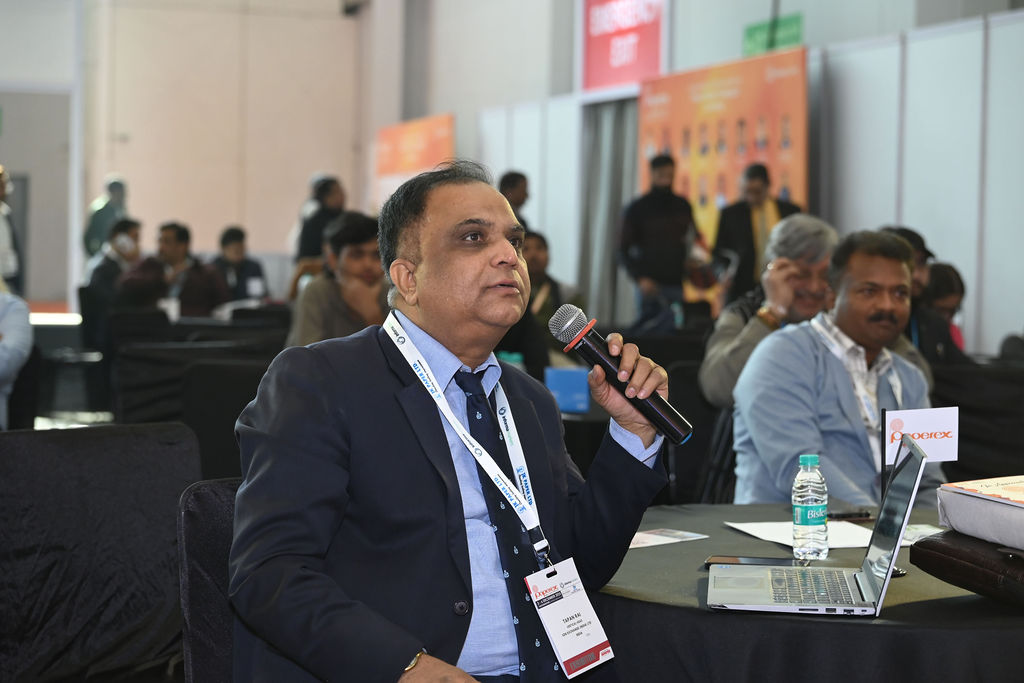 Business meeting at a trade show or conference with people seated at a small table.