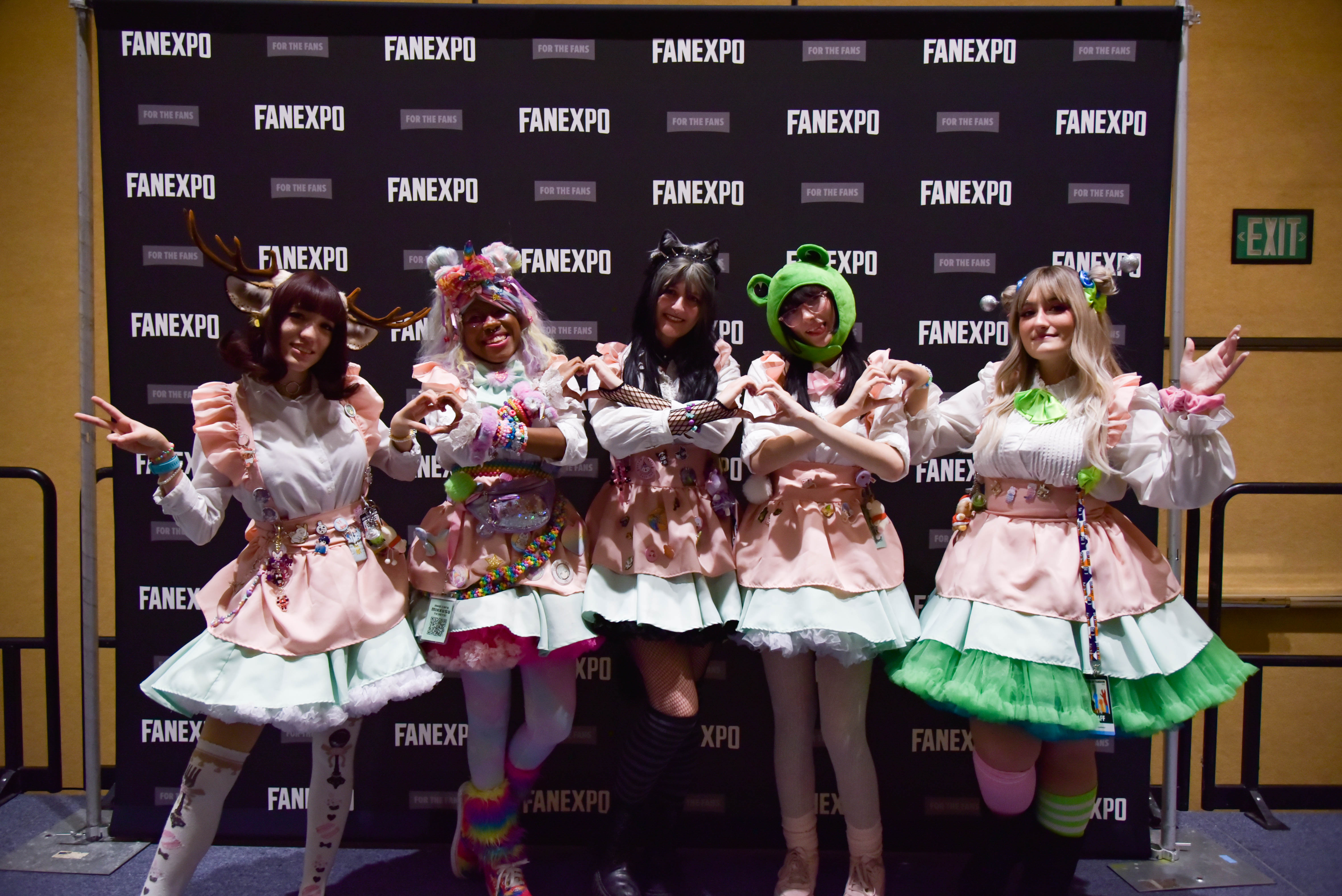 5 Maids dressed in cute pink and gray costumes making hearts with their hands