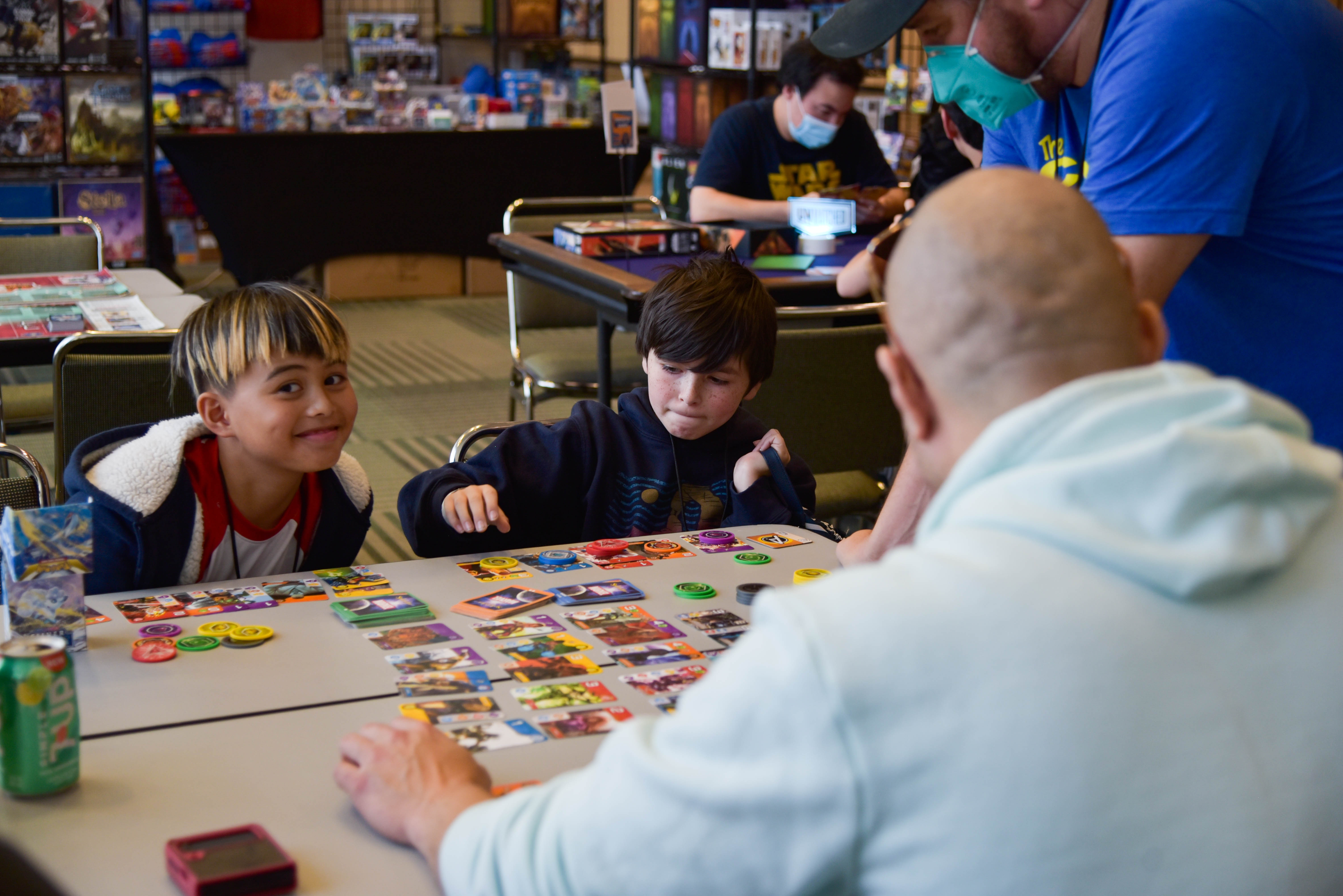 2 kids with their guardian playing card game