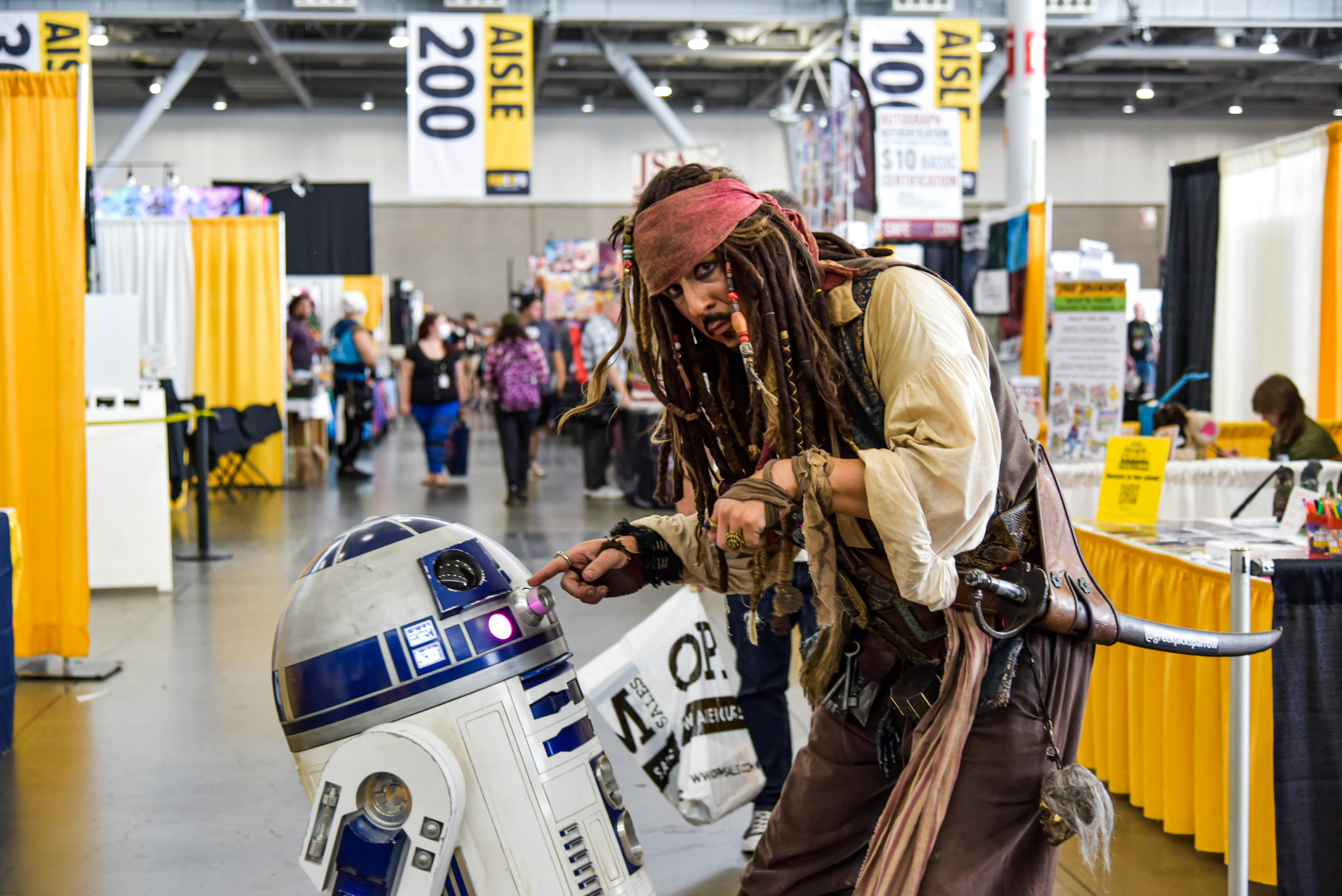 Captain Jack Sparrow from Disney's Pirate's of the Caribbean interacting with R2-D2 from Star Wars.