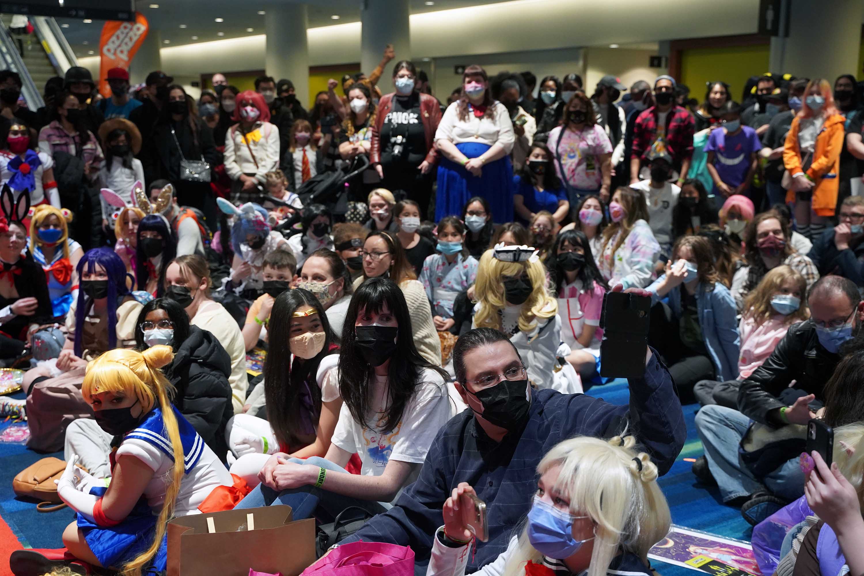 Fans waiting patiently at a carpet for a Sailor Moon event to start