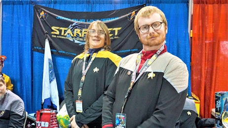 Star Trek cosplayers smiling at their table