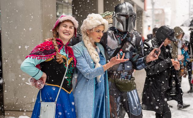 cosplayers reach out their hands to touch the snow