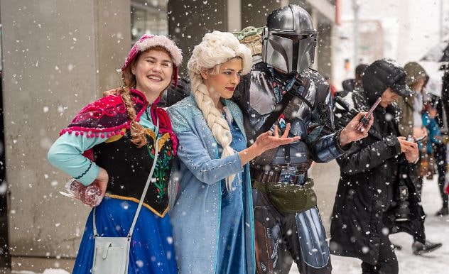 cosplayers reach out their hands to touch the snow