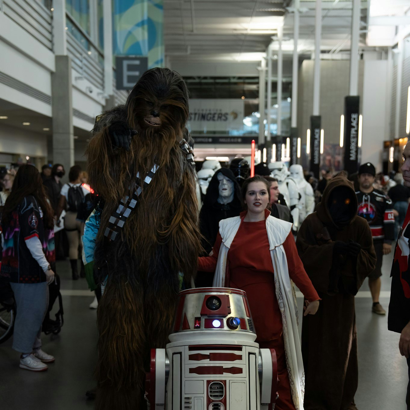 Chewbecca and Leia cosplayers poses with an R3 droid
