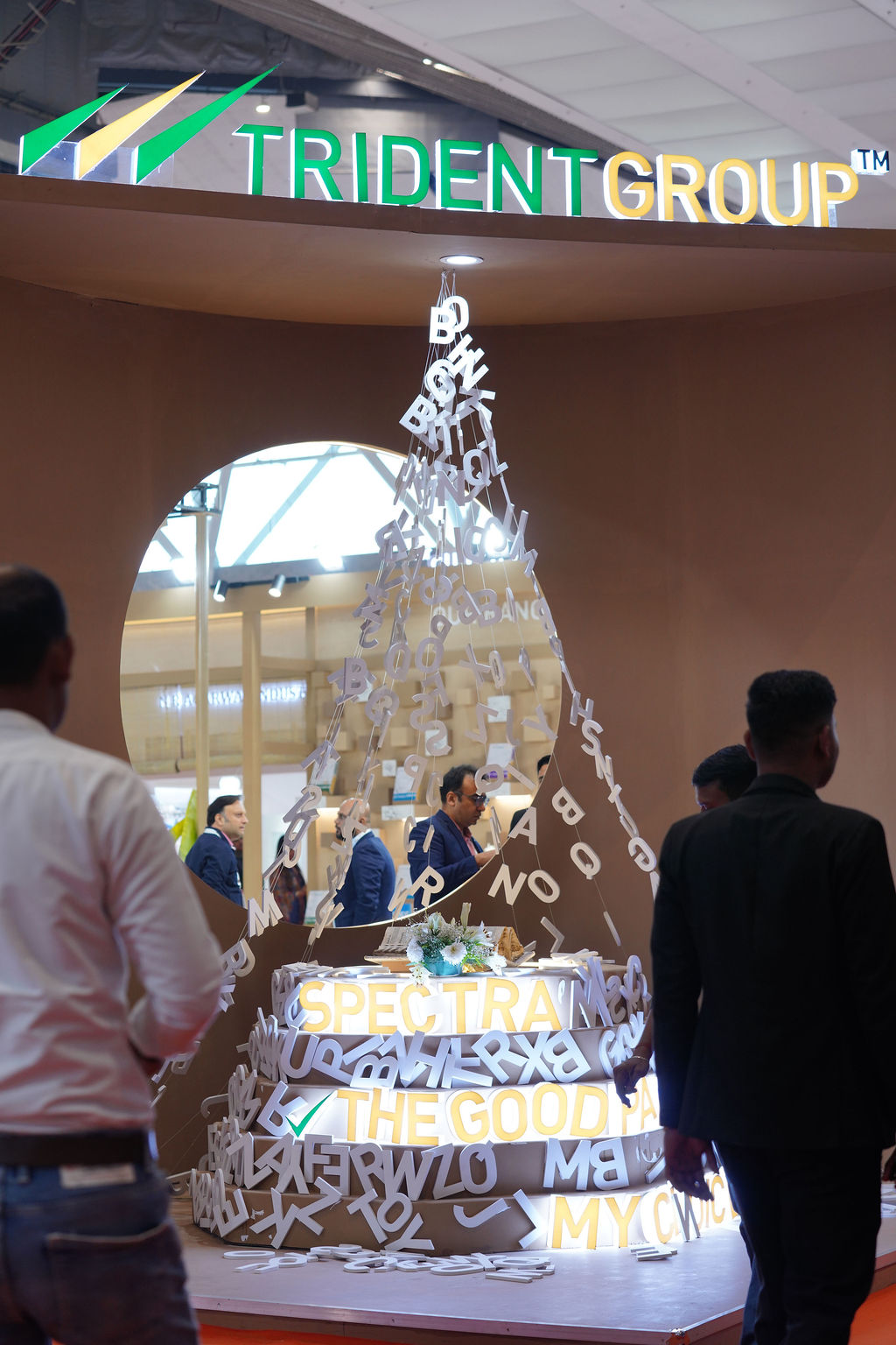 Group of professionals examining industrial machinery at a trade exhibition.