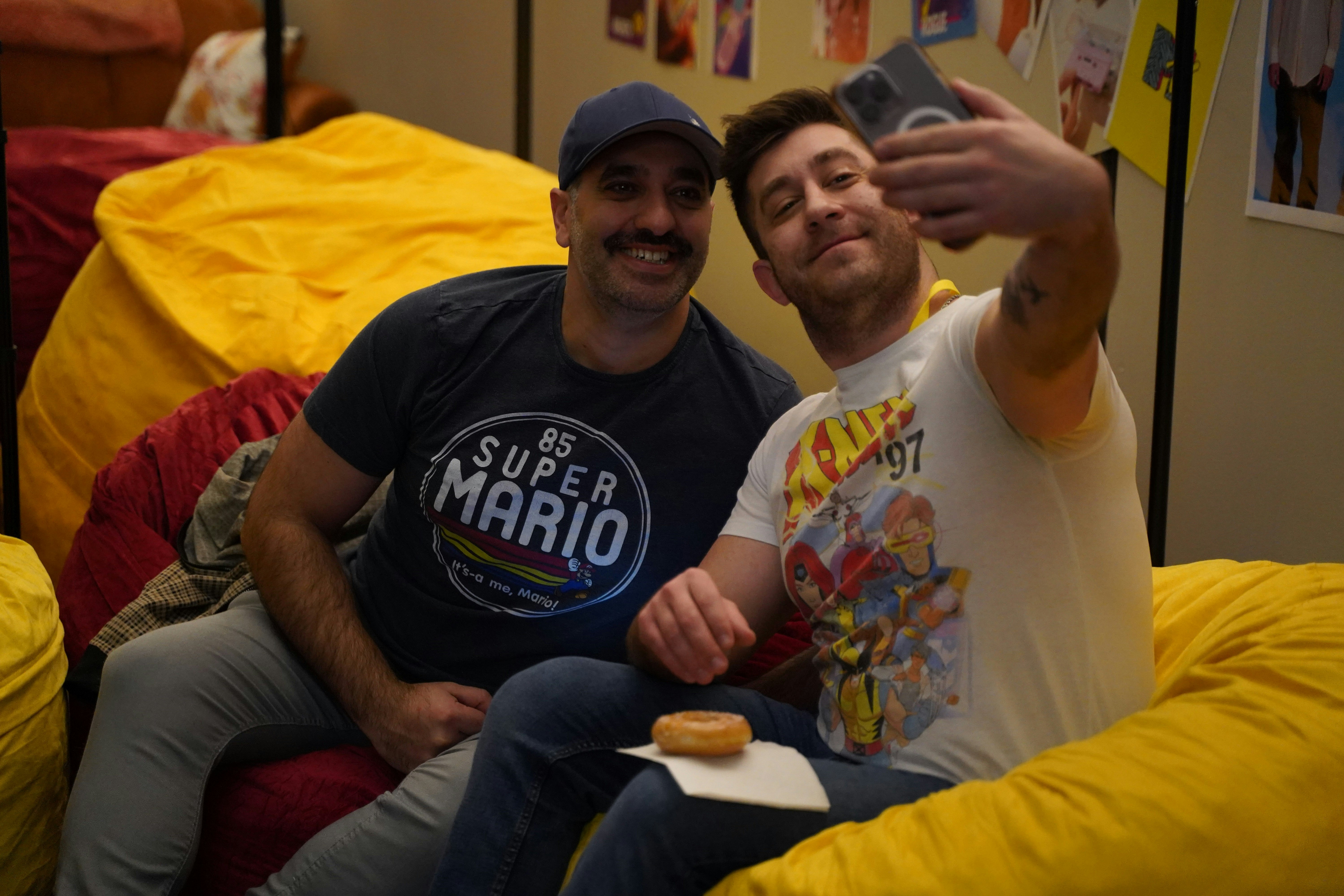 FANS SIT IN THE PROVIDED BEAN BAG CHAIRS AND POSE FOR A SELFIE.