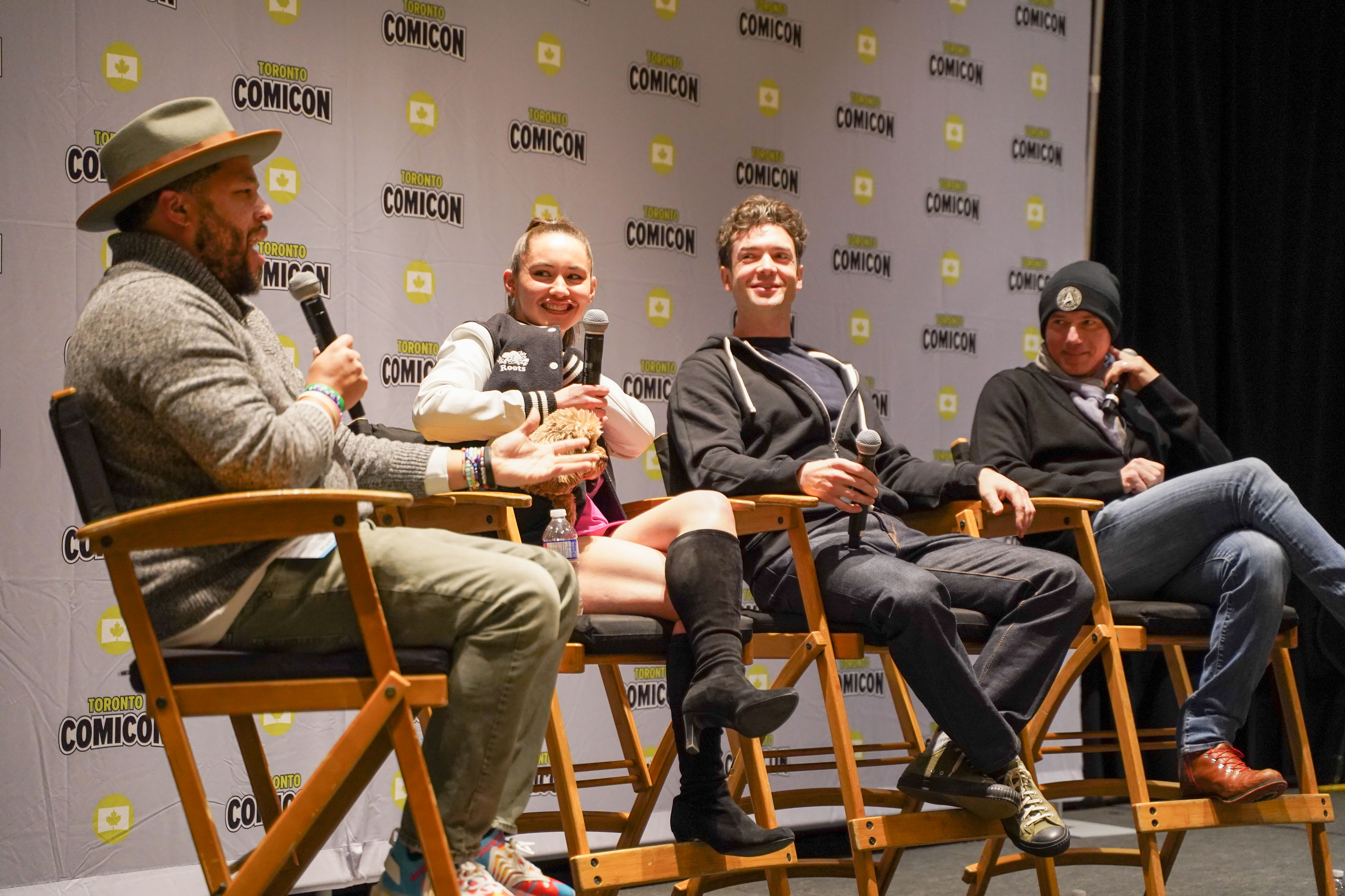 From left to right: Moderator, Christina Chong(and her small, fluffy dog Runa), Ethan Peck, Anson Mount. Our Star Trek stars smile at the moderator as he asks another question